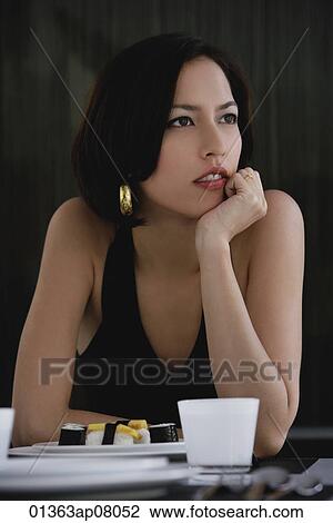 A woman sits at a table with a plate of sushi View Large Photo Image Stock Image - A woman sits at a table with a plate of sushi. Fotosearch