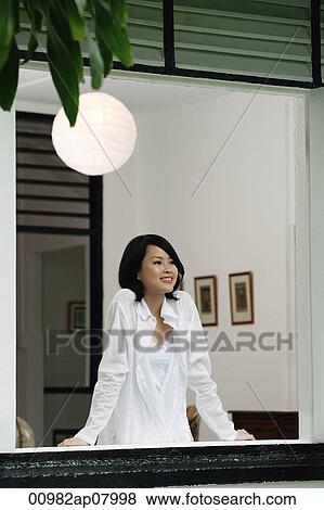 A woman smiles as she looks out the window View Large Photo Image Stock Photo - A woman smiles as she looks out the window. Fotosearch