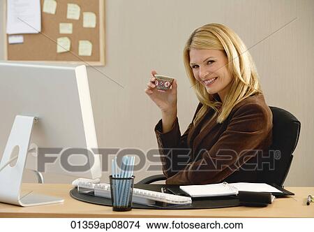 A woman smiles at the camera as she drinks Chinese tea View Large Photo Image Picture - A woman smiles at the camera as she drinks Chinese tea. Fotosearch