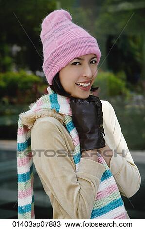 A woman tries to keep warm in a hat and gloves as she smiles at the camera View Large Photo Image Stock Image - A woman tries to keep warm in a hat and gloves as she smiles at the camera. Fotosearch