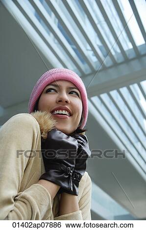 A woman tries to keep warm in a hat and gloves View Large Photo Image Stock Photograph - A woman tries to keep warm in a hat and gloves. Fotosearch