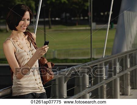 A woman uses her cellphone View Large Photo Image Stock Photography - A woman uses her cellphone. Fotosearch
