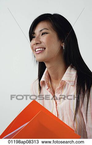 A woman with an orange folder View Large Photo Image Stock Image - A woman with an orange folder. Fotosearch
