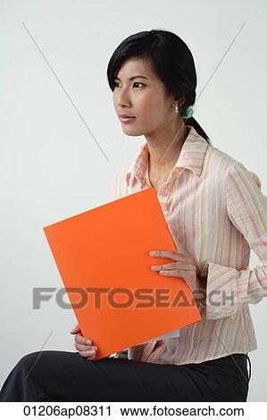 A woman with an orange folder View Large Photo Image Stock Image - A woman with an orange folder. Fotosearch