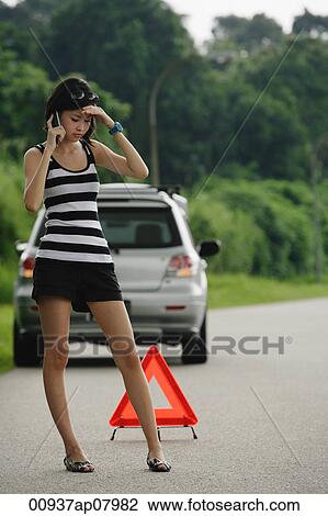 A woman with car trouble calls for help on her cellphone View Large Photo Image Stock Image - A woman with car trouble calls for help on her cellphone. Fotosearch