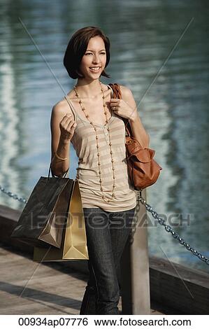 Stock Photograph - A woman with lots of shopping bags. Fotosearch
