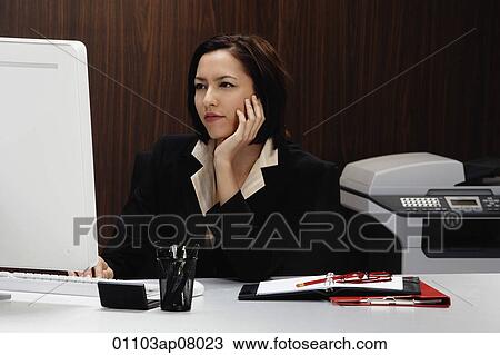 Stock Image - A woman working at her desk. Fotosearch