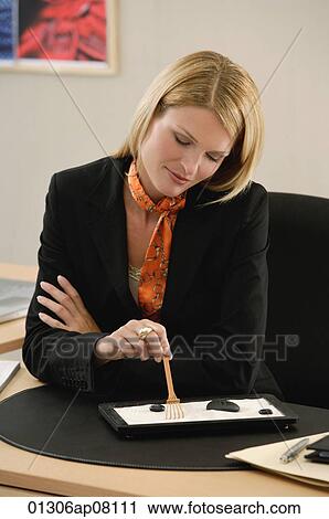 Stock Image - A woman works at her desk. Fotosearch