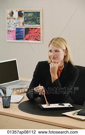 A woman works at her desk View Large Photo Image Stock Image - A woman works at her desk. Fotosearch