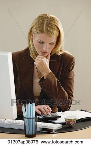 A woman works at her desk View Large Photo Image Stock Photograph - A woman works at her desk. Fotosearch