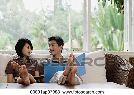 Stock Photo - A young couple read together. Fotosearch
