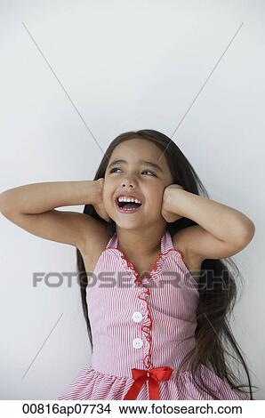 Picture - A young girl covers her ears with her hands. Fotosearch