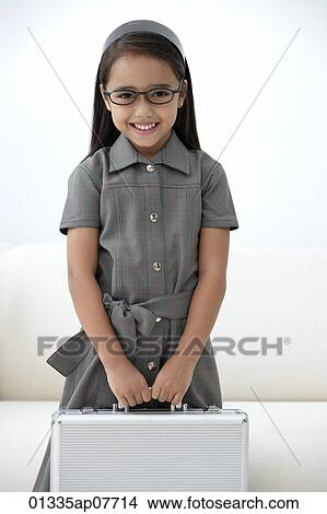 Picture - A young girl dressed in school uniform with glasses. Fotosearch