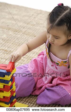 A young girl plays on the floor View Large Photo Image Stock Photography - A young girl plays on the floor. Fotosearch