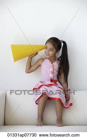 A young girl plays with a yellow cone View Large Photo Image Stock Image - A young girl plays with a yellow cone. Fotosearch