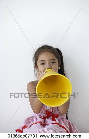 A young girl plays with a yellow cone View Large Photo Image Stock Image - A young girl plays with a yellow cone. Fotosearch