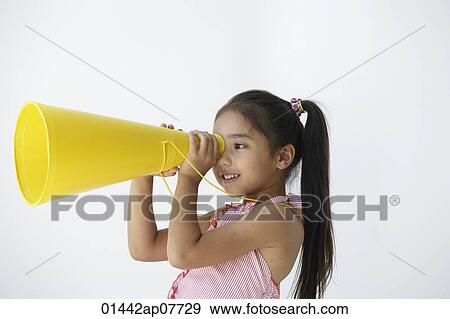 A young girl plays with a yellow cone View Large Photo Image Stock Photo - A young girl plays with a yellow cone. Fotosearch