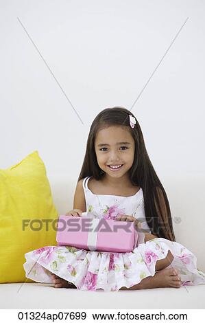 Stock Photo - A young girl with a birthday present. Fotosearch