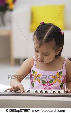 A young girl with a piano View Large Photo Image Stock Photo - A young girl with a piano. Fotosearch