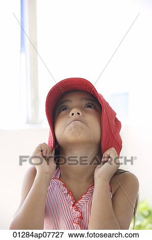 Stock Photo - A young girl with a red hat. Fotosearch