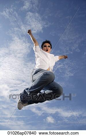 Stock Image - A young man jumps for joy. Fotosearch