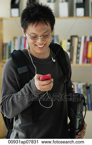 A young man listens to music in the library View Large Photo Image Stock Image - A young man listens to music in the library. Fotosearch