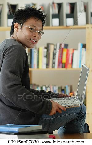 A young man studies in the library View Large Photo Image Stock Image - A young man studies in the library. Fotosearch