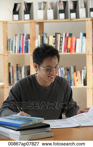 A young man studies in the library View Large Photo Image Stock Photo - A young man studies in the library. Fotosearch