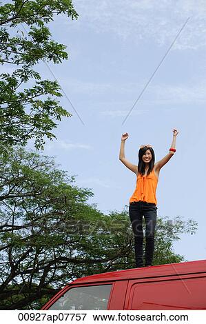 A young woman dances on the top of a red van View Large Photo Image Stock Photo - A young woman dances on the top of a red van. Fotosearch