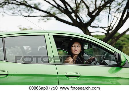 A young woman drives a green car View Large Photo Image Stock Image - A young woman drives a green car. Fotosearch