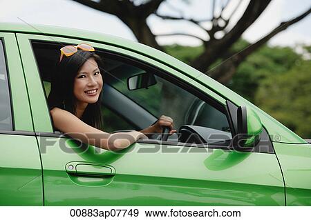 A young woman drives a green car View Large Photo Image Stock Photo - A young woman drives a green car. Fotosearch