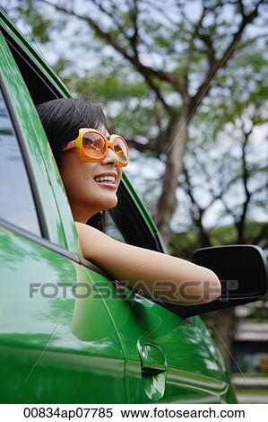 A young woman drives a green car View Large Photo Image Stock Photography - A young woman drives a green car. Fotosearch