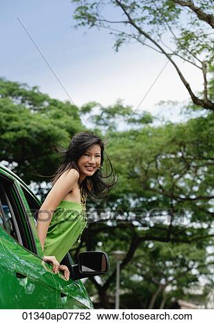 A young woman leans out of the window of a car View Large Photo Image Stock Image - A young woman leans out of the window of a car. Fotosearch