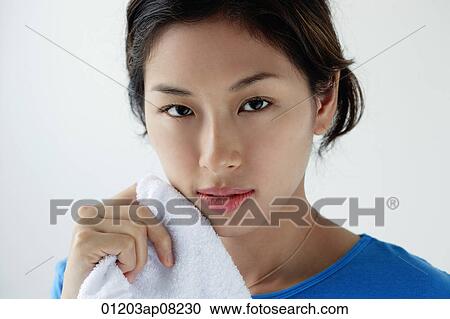 A young woman looks at the camera as she washes her face View Large Photo Image Stock Image - A young woman looks at the camera as she washes her face. Fotosearch