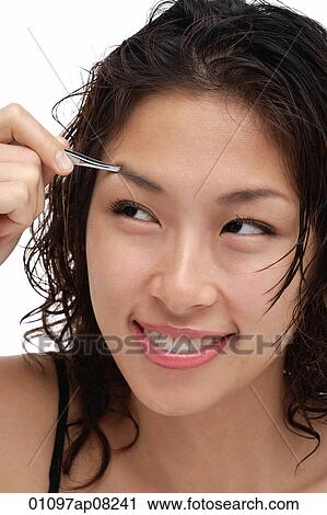 A young woman shapes her eyebrows View Large Photo Image Stock Image - A young woman shapes her eyebrows. Fotosearch