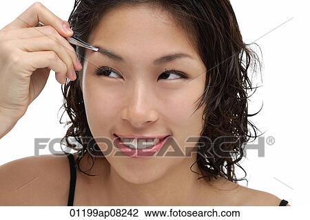 A young woman shapes her eyebrows View Large Photo Image Stock Image - A young woman shapes her eyebrows. Fotosearch