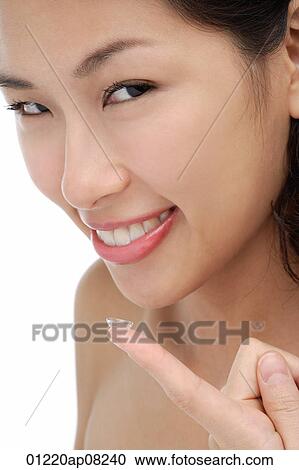 A young woman smiles at the camera a she puts a contact lens in View Large Photo Image Stock Image - A young woman smiles at the camera a she puts a contact lens in. Fotosearch