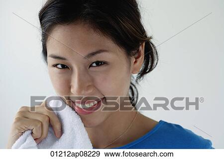 A young woman smiles at the camera as she washes her face View Large Photo Image Stock Photo - A young woman smiles at the camera as she washes her face. Fotosearch