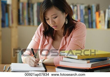 A young woman studies in the library View Large Photo Image Picture - A young woman studies in the library. Fotosearch