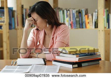 A young woman studies in the library View Large Photo Image Stock Photography - A young woman studies in the library. Fotosearch