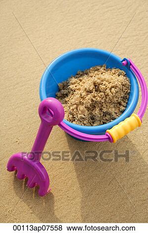 Beach Bucket filled with sand and shovel leaning against bucket View Large Photo Image Stock Photo - Beach Bucket filled with sand and shovel leaning against bucket. Fotosearch