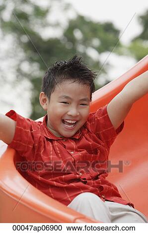 Boy coming down playground slide, arms outstretched, smiling View Large Photo Image Stock Image - Boy coming down playground slide, arms outstretched, smiling. Fotosearch