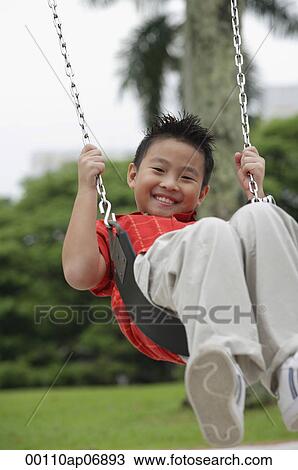 Boy swinging, smiling at camera View Large Photo Image Stock Image - Boy swinging, smiling at camera. Fotosearch