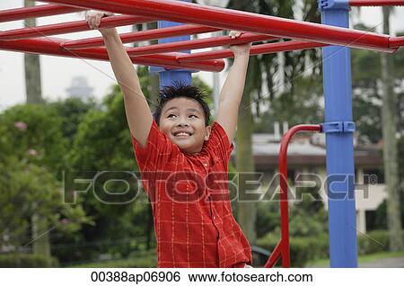 Stock Photograph - Boy using the jungle gym at playground. Fotosearch