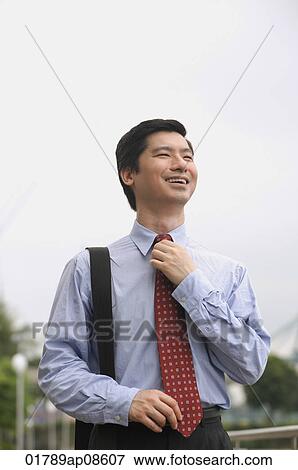 Businessman adjusting his tie View Large Photo Image Stock Photo - Businessman adjusting his tie. Fotosearch
