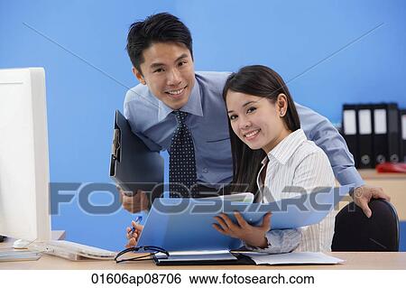 Businessman and woman smiling at camera View Large Photo Image Stock Photograph - Businessman and woman smiling at camera. Fotosearch
