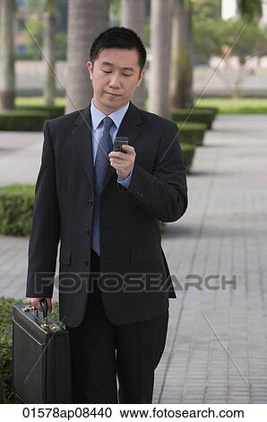 Businessman holding mobile phone View Large Photo Image Stock Image - Businessman holding mobile phone. Fotosearch