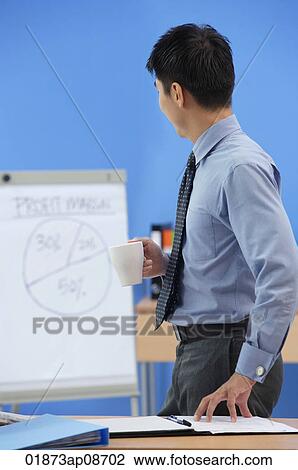 Stock Image - Businessman looking at statistics. Fotosearch