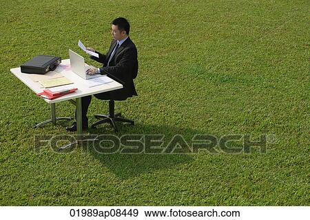 Businessman working at desk View Large Photo Image Stock Photo - Businessman working at desk. Fotosearch