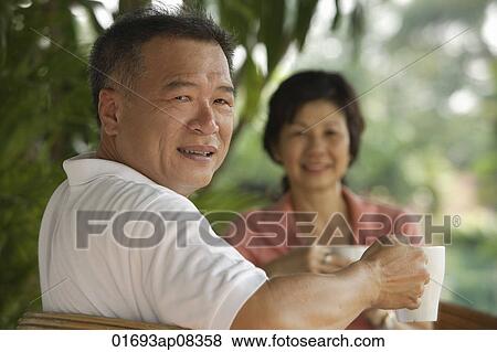 Couple drinking tea in the garden View Large Photo Image Stock Photo - Couple drinking tea in the garden. Fotosearch